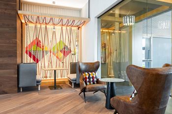 a lobby with chairs and a table in front of a glass door at The Chase at Bryant Street, Washington, DC 20002